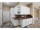 Charming kitchen with custom white cabinetry and granite countertops with a view into the home at 5904 Pelican Bay S Plz, Gulfport, FL 33707