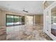 Spacious living room with travertine floors and access to the pool area through sliding glass doors at 5904 Pelican Bay S Plz, Gulfport, FL 33707