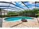 Relaxing screened in pool area features a fire pit, brick pavers, and lush landscaping at 5904 Pelican Bay S Plz, Gulfport, FL 33707