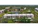An aerial view of the building, lush greenery, and a peaceful lake with a fountain at 5920 80Th N St # 406, St Petersburg, FL 33709