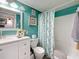 Bathroom featuring a white vanity, a shower/tub combo with blue-green walls and a decorative shower curtain at 5920 80Th N St # 406, St Petersburg, FL 33709