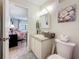 Bathroom with white vanity and fixtures, and a glimpse into the light-filled adjacent bedroom at 5920 80Th N St # 406, St Petersburg, FL 33709