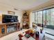 Bright living room with hardwood floors, entertainment center and sliding glass doors to the balcony at 5920 80Th N St # 406, St Petersburg, FL 33709