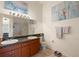 Bathroom featuring a double sink vanity with framed mirror, artwork, and a separate shower at 6336 Bayside Key Dr, Tampa, FL 33615