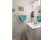Clean half bathroom with a white vanity, light fixtures and wall art at 6336 Bayside Key Dr, Tampa, FL 33615