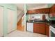 Spacious kitchen boasting wooden cabinets and white appliances adjacent to stairs at 6336 Bayside Key Dr, Tampa, FL 33615