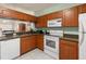 Well-equipped kitchen featuring wooden cabinets, granite countertops, and white appliances at 6336 Bayside Key Dr, Tampa, FL 33615