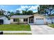 Charming single-story home featuring a well-manicured lawn, stone accents and attached garage at 6460 101St N Ave, Pinellas Park, FL 33782