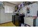 Laundry room features a washer, dryer, utility sink, and storage shelves with laundry supplies at 6460 101St N Ave, Pinellas Park, FL 33782