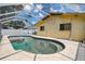 A swimming pool with a concrete deck and screened enclosure next to the house at 6460 101St N Ave, Pinellas Park, FL 33782