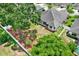 Aerial view of a private backyard featuring a lush lawn, mature tree, and white perimeter fence at 679 Challice Dr, Spring Hill, FL 34609