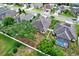 Neighborhood aerial view showing a fenced backyard with lush trees and a screened-in pool area at 679 Challice Dr, Spring Hill, FL 34609