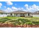 Expansive backyard features a well-manicured lawn and a charming covered patio perfect for outdoor entertaining at 679 Challice Dr, Spring Hill, FL 34609