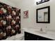 Cozy bathroom features a vanity with a decorative mirror and a shower with a patterned floral curtain at 679 Challice Dr, Spring Hill, FL 34609