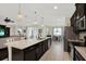 Gourmet kitchen with granite island, stainless appliances, seamlessly connects to living and dining areas for open concept appeal at 679 Challice Dr, Spring Hill, FL 34609