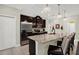 Modern kitchen with dark cabinets, granite countertops, stainless steel appliances, and a breakfast bar for casual dining at 679 Challice Dr, Spring Hill, FL 34609