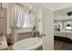 Relaxing main bathroom with soaking tub, chandelier lighting, and decorative window treatments for added privacy at 679 Challice Dr, Spring Hill, FL 34609