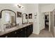 Stylish main bathroom features double sinks, granite countertop, dark cabinetry, and a walk-in closet at 679 Challice Dr, Spring Hill, FL 34609