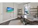 Well-organized home office, featuring a desk, shelves, and mounted TV at 679 Challice Dr, Spring Hill, FL 34609