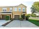 Two-story townhome featuring a one-car garage and a well-maintained front yard with green bushes at 6940 47Th N Way, Pinellas Park, FL 33781