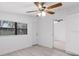 Spacious bedroom with ceiling fan, gray floors, and view to adjacent bedroom at 8009 Somerset Ln, Tampa, FL 33615