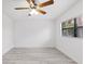 Empty bedroom with a ceiling fan, gray floors, and natural light from the window at 8009 Somerset Ln, Tampa, FL 33615