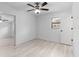 Bedroom featuring light floors, a ceiling fan, and a window with a view of foliage at 8009 Somerset Ln, Tampa, FL 33615
