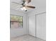 A bright bedroom with a ceiling fan, closet, and large window at 8009 Somerset Ln, Tampa, FL 33615