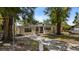 Welcoming home featuring mature trees, a paved driveway, and a well-maintained front lawn at 8009 Somerset Ln, Tampa, FL 33615
