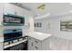 Modern kitchen with stainless steel appliances, white cabinets, quartz countertops, and an island at 8009 Somerset Ln, Tampa, FL 33615