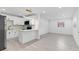 Modern kitchen and living space with stainless steel appliances and sleek gray flooring at 8009 Somerset Ln, Tampa, FL 33615
