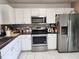 Bright kitchen features stainless steel appliances, white cabinets, and dark countertops at 8313 Arabian Dunes Pl, Riverview, FL 33578