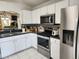 Bright kitchen featuring modern stainless steel appliances and white cabinets at 8313 Arabian Dunes Pl, Riverview, FL 33578