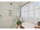 Modern bathroom featuring a glass-enclosed shower, clawfoot tub, and elegant black and white tiled floor at 848 9Th S Ave, St Petersburg, FL 33701