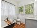Bright bathroom with a vintage clawfoot tub, sheer curtains, and a modern gray vanity with stone countertop at 848 9Th S Ave, St Petersburg, FL 33701