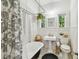 Bright bathroom featuring a clawfoot tub, pedestal sink, and black-and-white floral shower curtain at 848 9Th S Ave, St Petersburg, FL 33701