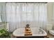 Serene bathroom featuring a vintage clawfoot tub, sheer curtains and natural light at 848 9Th S Ave, St Petersburg, FL 33701