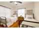 Bright bedroom with twin beds, hardwood floors, natural light, and stylish floral artwork at 848 9Th S Ave, St Petersburg, FL 33701