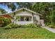Inviting bungalow showcasing a covered front porch, lush landscaping, and a well-manicured lawn at 848 9Th S Ave, St Petersburg, FL 33701