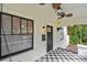 Charming front porch view featuring a swing, ceiling fans, and stylish checkered flooring at 848 9Th S Ave, St Petersburg, FL 33701