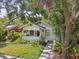 Charming home featuring a covered front porch, lush landscaping, and mature trees at 848 9Th S Ave, St Petersburg, FL 33701