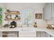Kitchen sink beneath a window, complemented by floating shelves and stylish decor at 848 9Th S Ave, St Petersburg, FL 33701