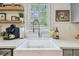 Stylish kitchen sink area with white countertops, floating shelves, and modern fixtures for a functional design at 848 9Th S Ave, St Petersburg, FL 33701