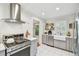 Bright kitchen with stainless steel appliances, white tile backsplash, gray cabinets and white tile floors at 848 9Th S Ave, St Petersburg, FL 33701