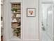 Organized linen closet with woven baskets, white towels, and plants next to a modern black and white bathroom at 848 9Th S Ave, St Petersburg, FL 33701