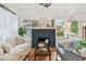 Charming living room features a dark-bricked fireplace, hardwood floors, and natural lighting from the windows at 848 9Th S Ave, St Petersburg, FL 33701