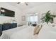 Elegant primary bedroom with a ceiling fan, hardwood floors, and a TV for a relaxing and comfortable personal space at 848 9Th S Ave, St Petersburg, FL 33701