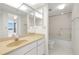 Bright bathroom with white vanity, sink, toilet, and shower at 9425 Blind Pass Rd # 1008, St Pete Beach, FL 33706
