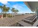 Community deck with many lounge chairs, palm trees and water views at 9425 Blind Pass Rd # 1008, St Pete Beach, FL 33706