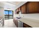 Functional kitchen space offering warm wood cabinets and views of the water from a picture window at 9425 Blind Pass Rd # 1008, St Pete Beach, FL 33706